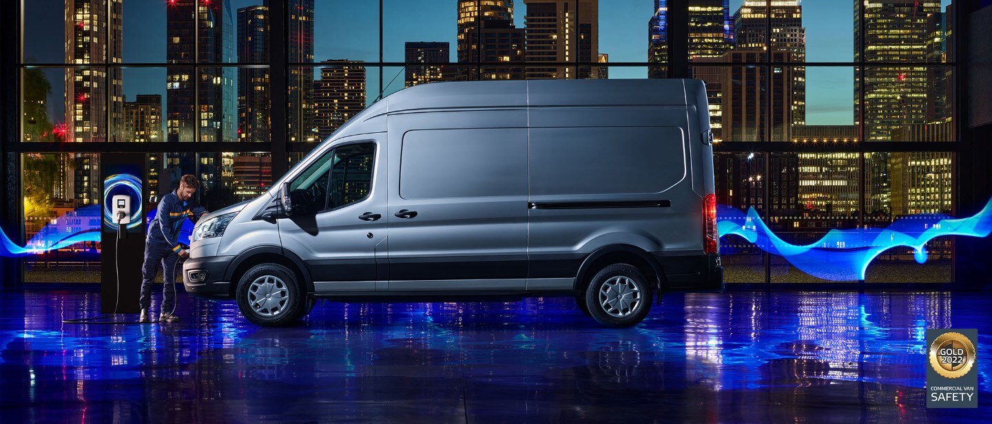 New E-Transit side view with the backdrop of city in night with blue electric lights New E-Transit side view with the backdrop of city in night with blue electric lights