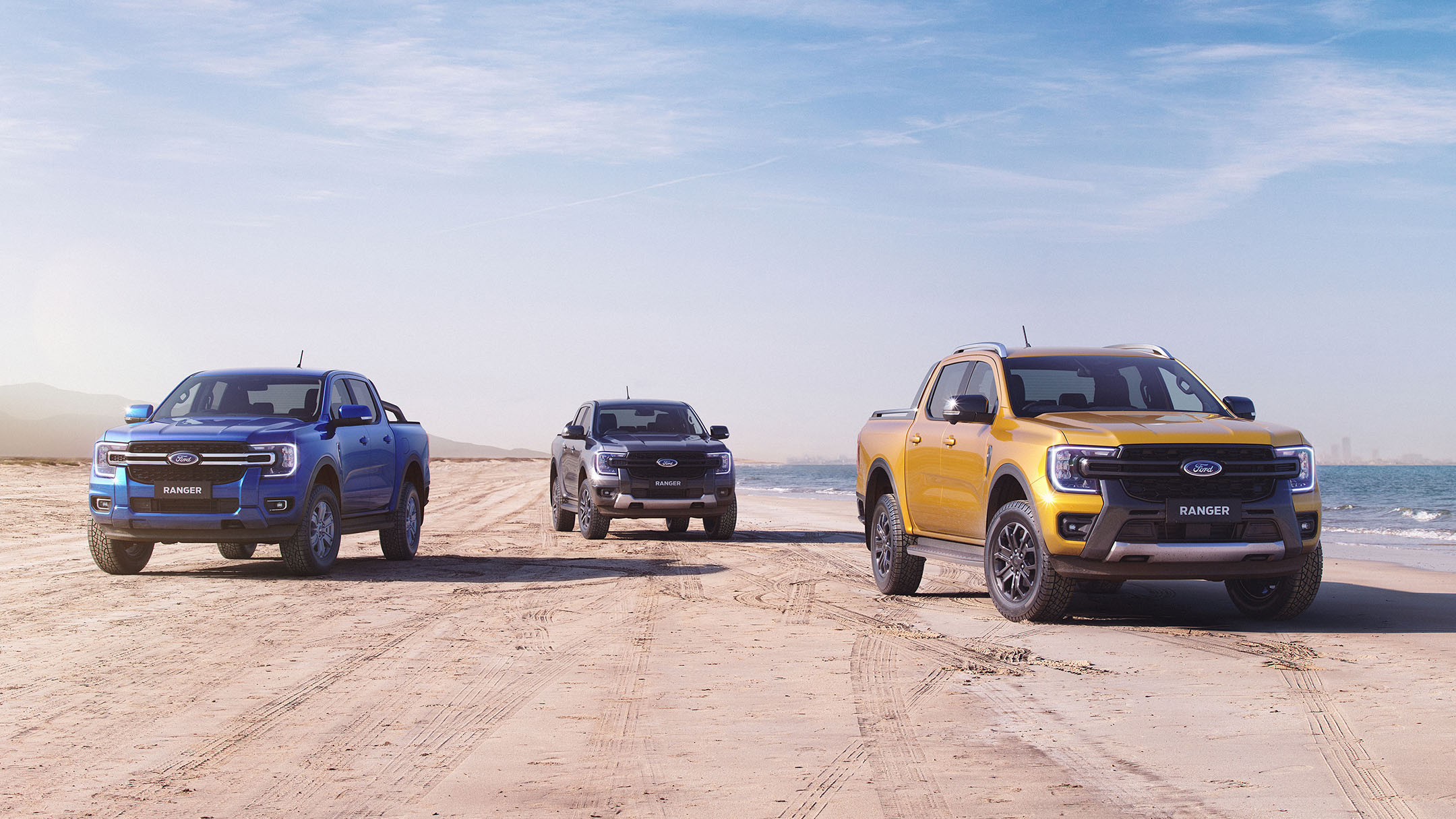 Three Ford Rangers parked on shoreline