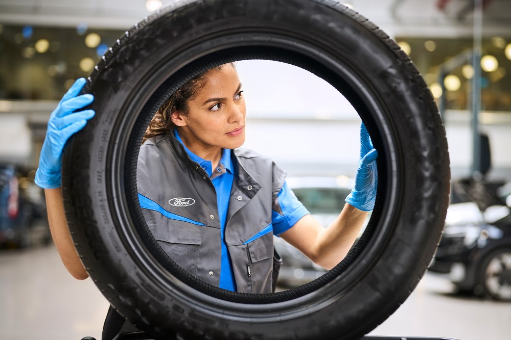 Mecânico da Ford a agarrar num oneu