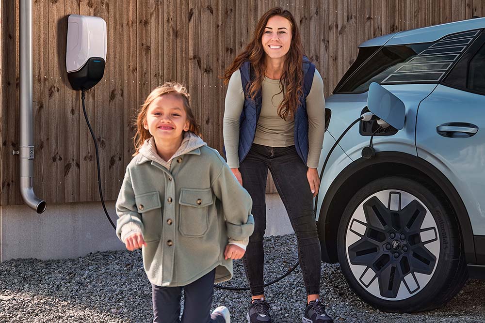 Uma família a divertir-se enquanto carrega o seu Ford Explorer elétrico em casa.