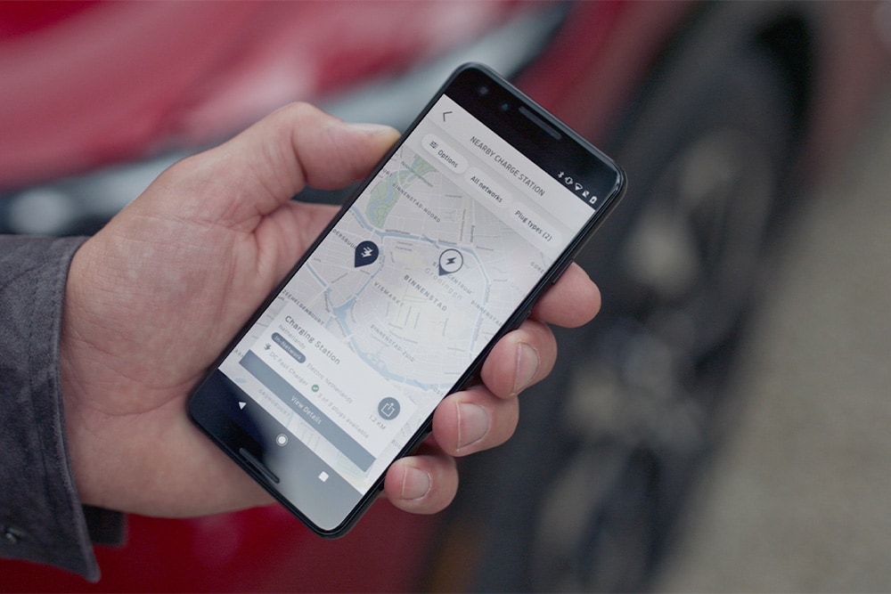 Um smartphone a apresentar a aplicação FordPass™ com pontos de carregamento próximos para carregamento público de veículos elétricos da Ford.