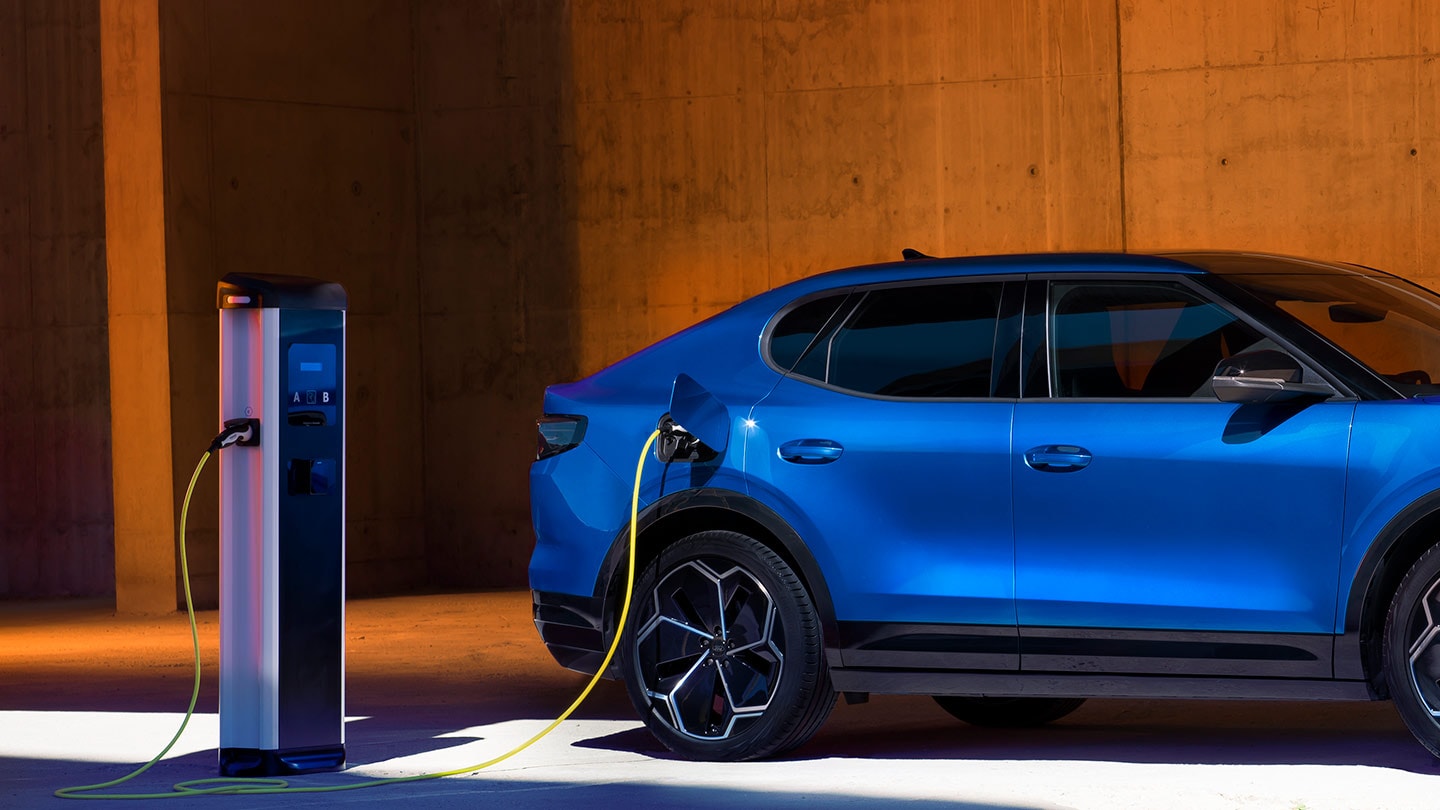 Um veículo elétrico Ford Capri azul conectado a um carregador EV.