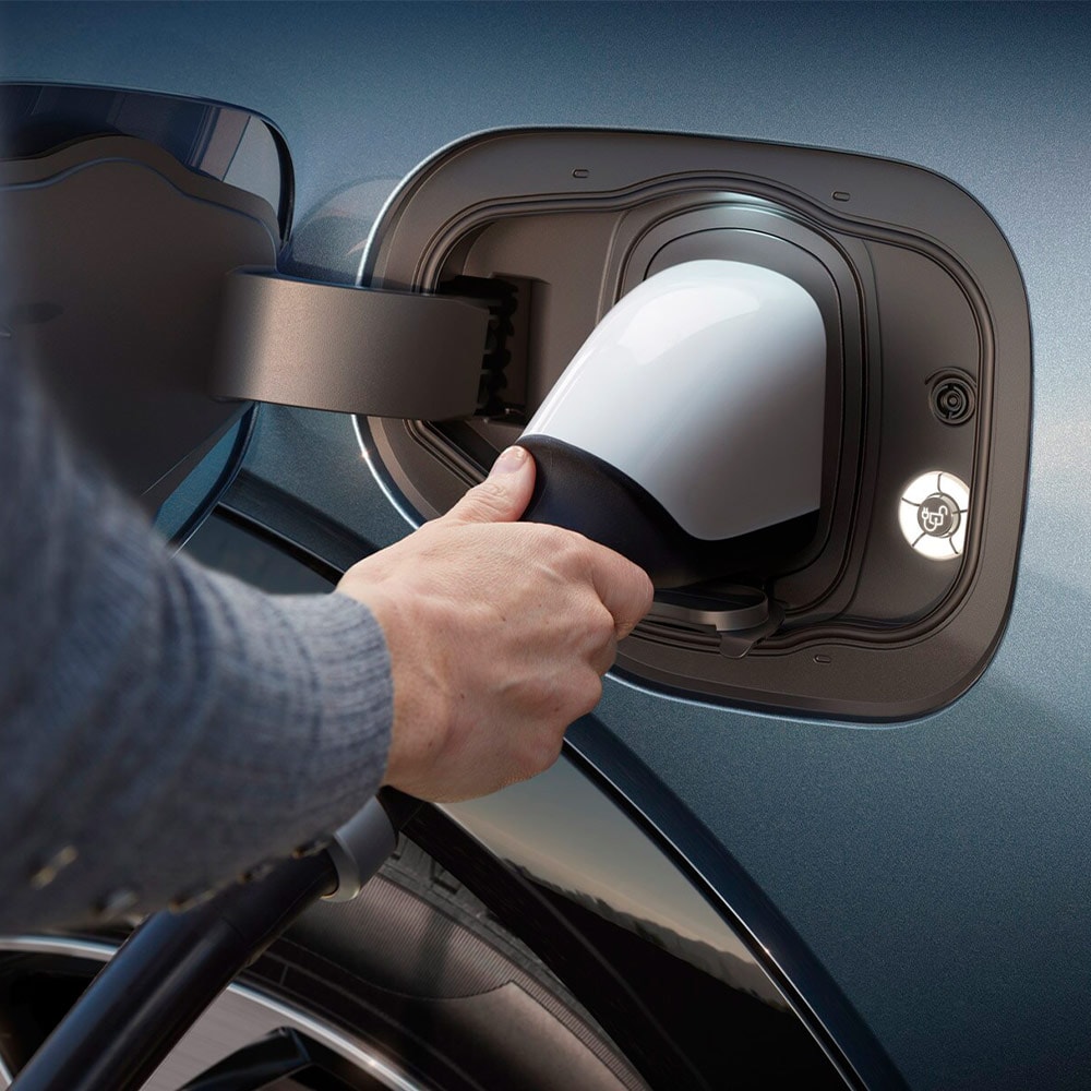 Uma pessoa conectando um carregador de EV ultrarrápido a um veículo elétrico da Ford.