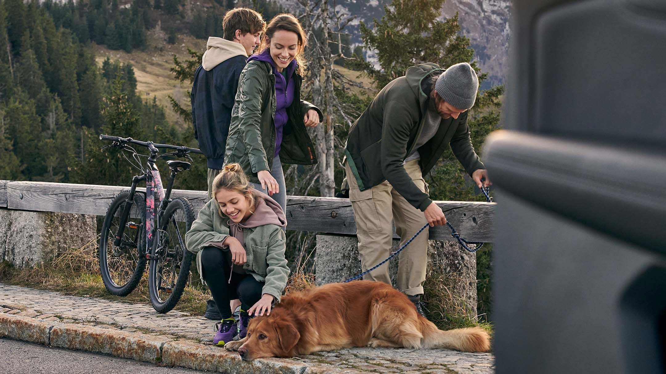 A family of four with a dog having fun on a trip