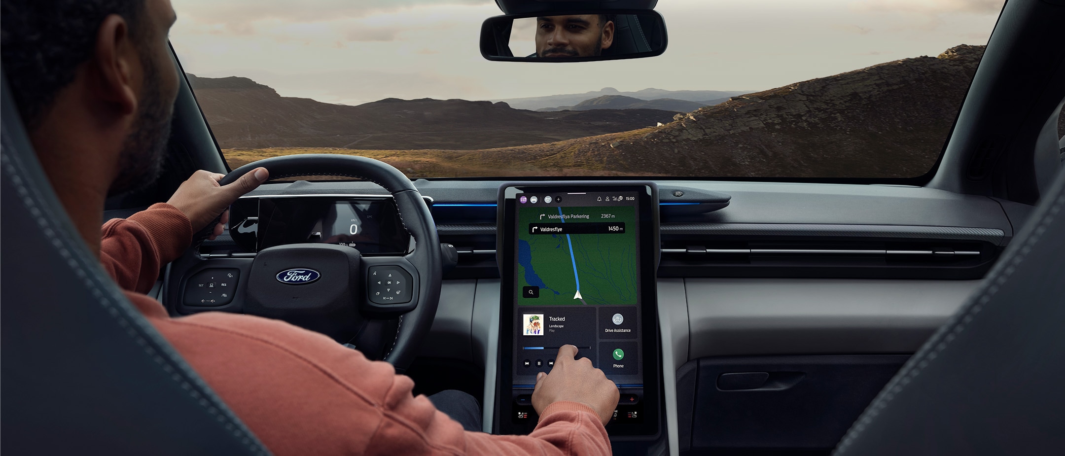 Homem sentado no banco do condutor do Ford Explorer, a interagir com o ecrã tátil grande do SYNC.