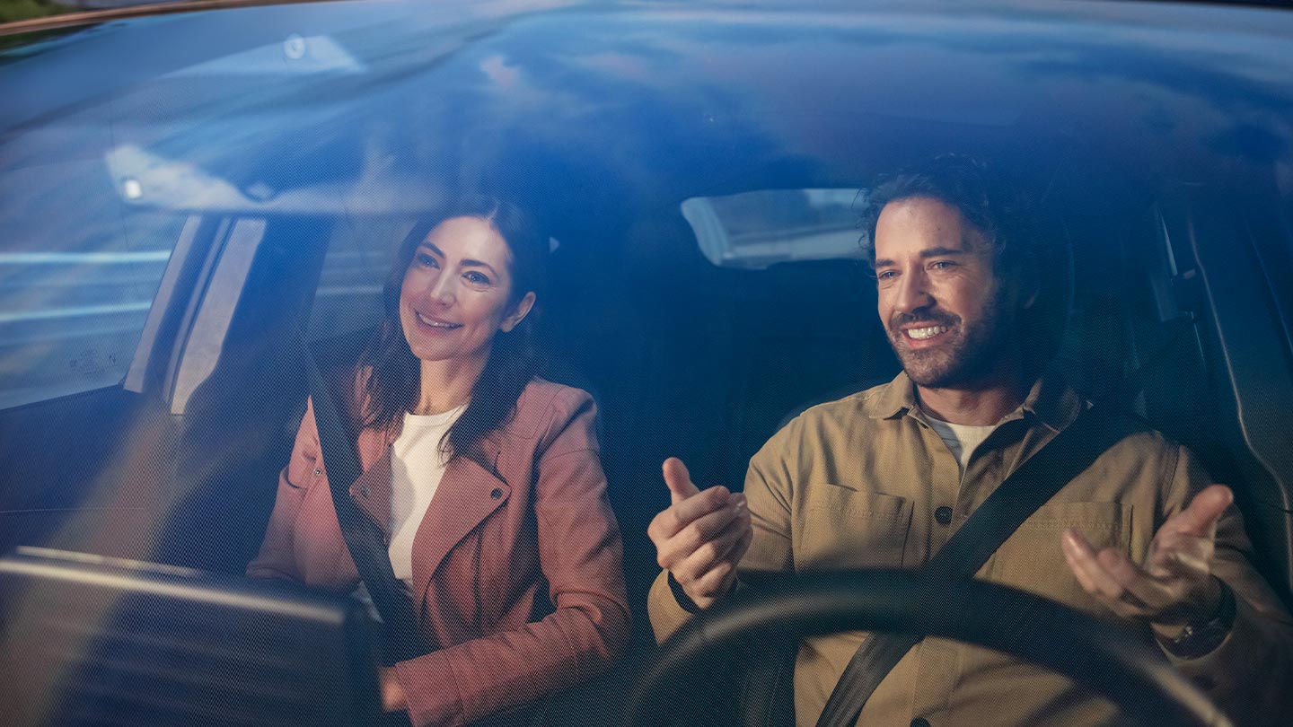 Duas pessoas sentadas nos bancos dianteiros de um veículo Ford, ambas usando cintos de segurança.