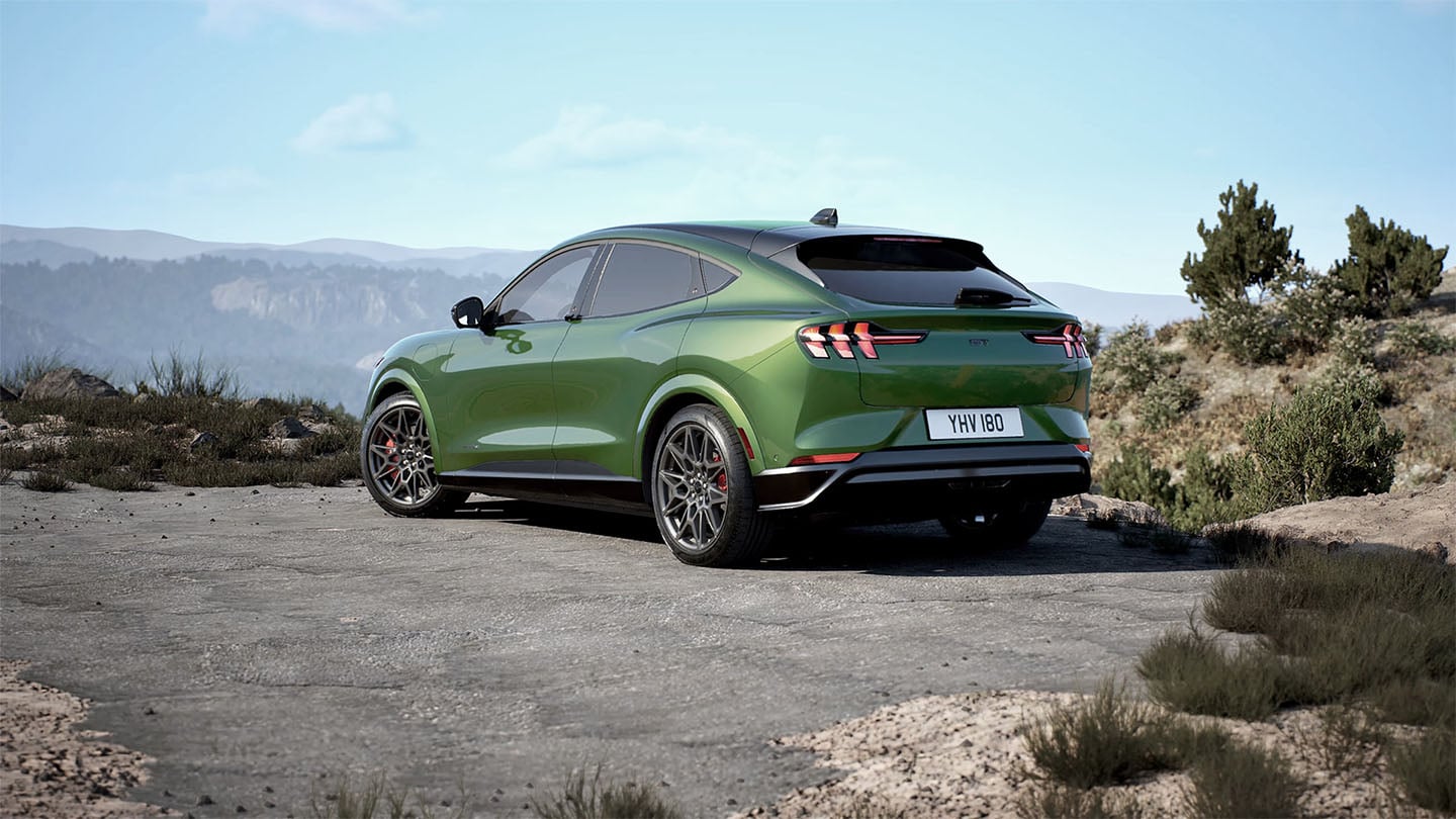 Traseira do Ford Mustang Mach-E GT em Eruption Green numa estrada de montanha.