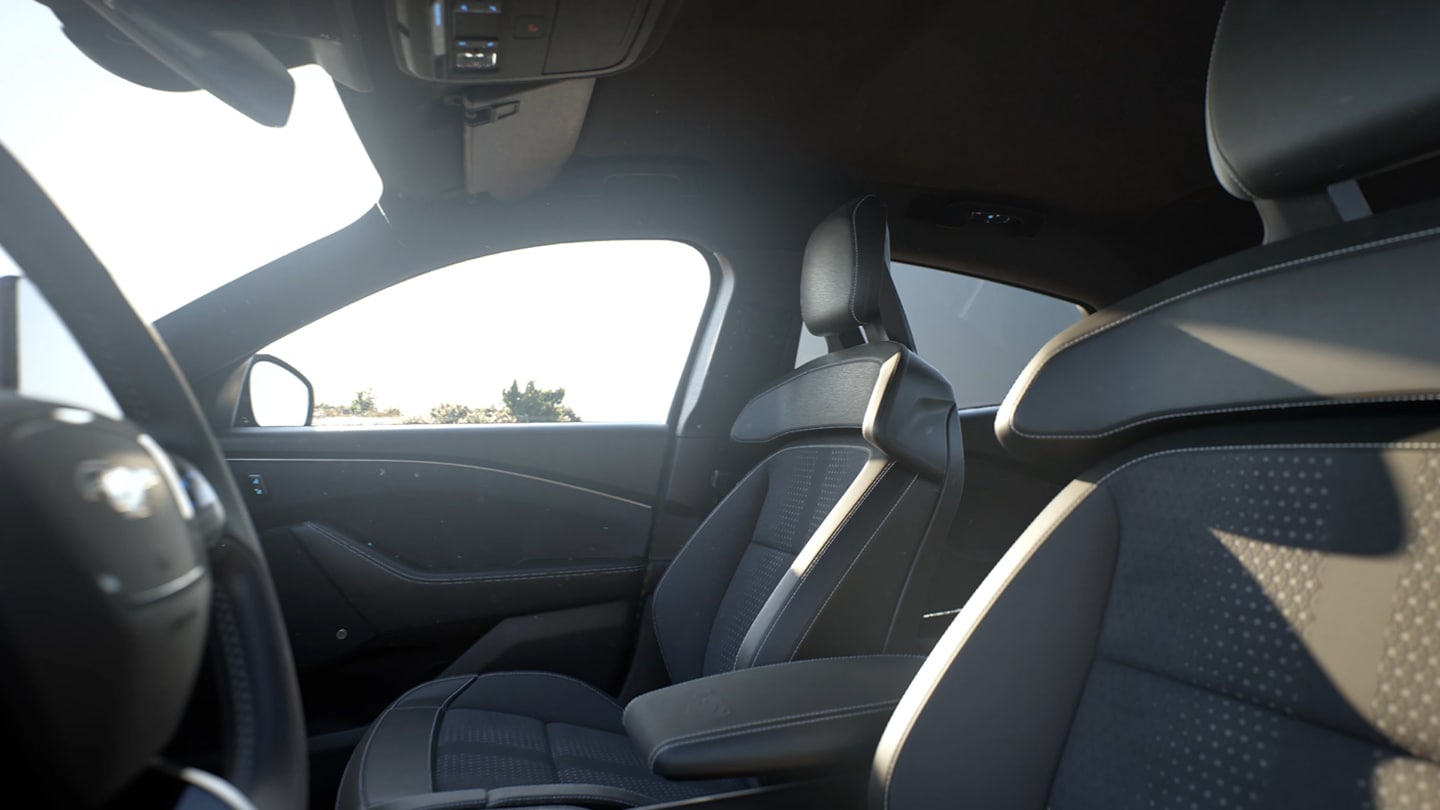 Interior do Ford Mustang Mach-E, a mostrar os cinco confortáveisbancos com acabamento em preto e costuras vermelhas.