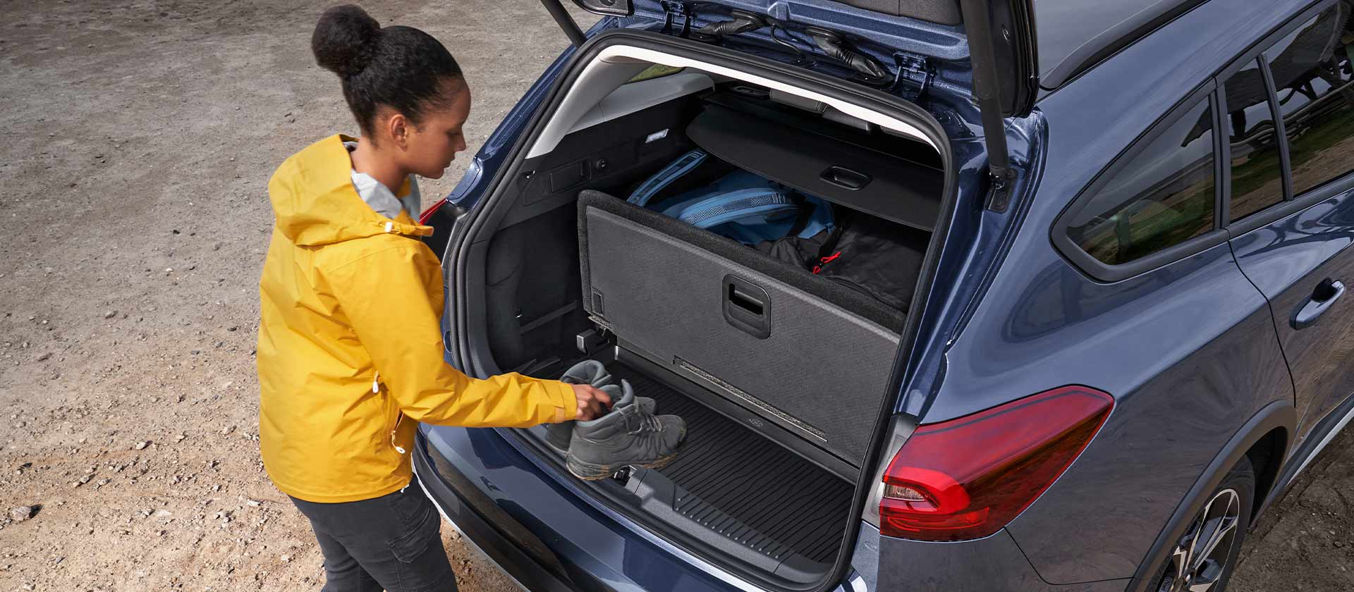 Mulher a colocar sapatos no porta-bagagens de um Ford Focus