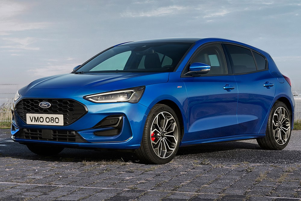 Um Ford Focus ST-Line 5 portas azul com pinças de freio vermelhas estacionado em uma superfície pavimentada.