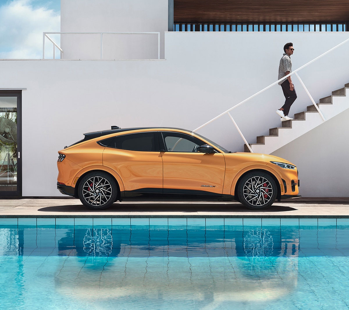 Mach-E GT em amarelo estacionado em uma casa