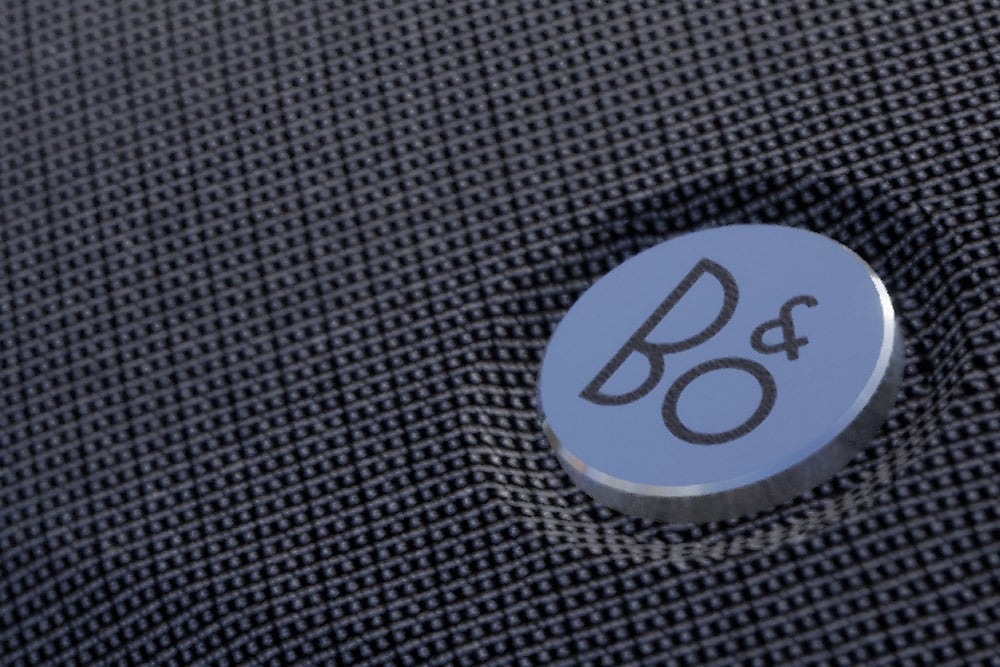 Grande plano de um detalhe com o símbolo da marca Bang & Olufsen no interior do Ford Bronco.