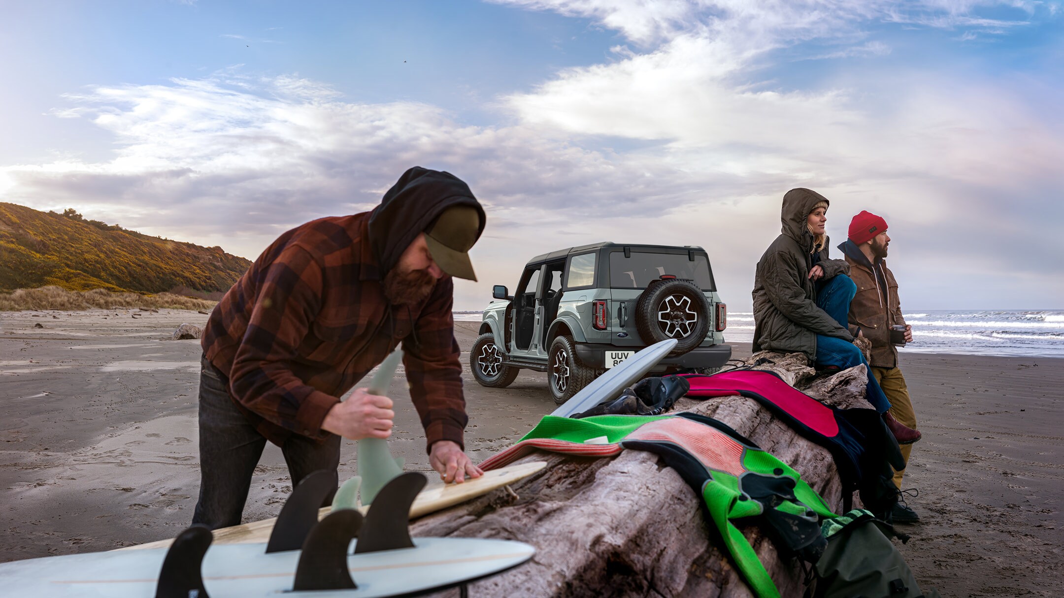 Ford Bronco na praia com pranchas de surf