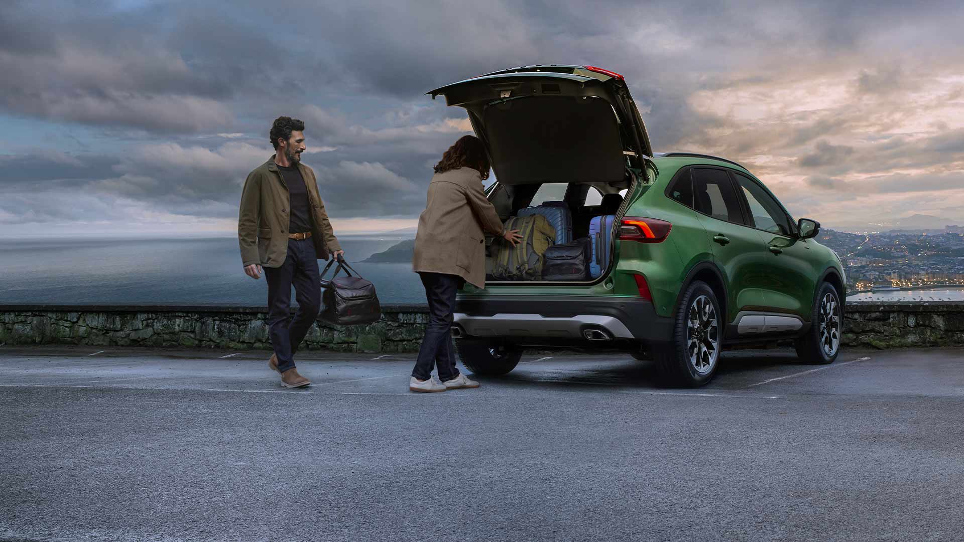 Pessoa a carregar várias malas na espaçosa bagageira do Ford Kuga.