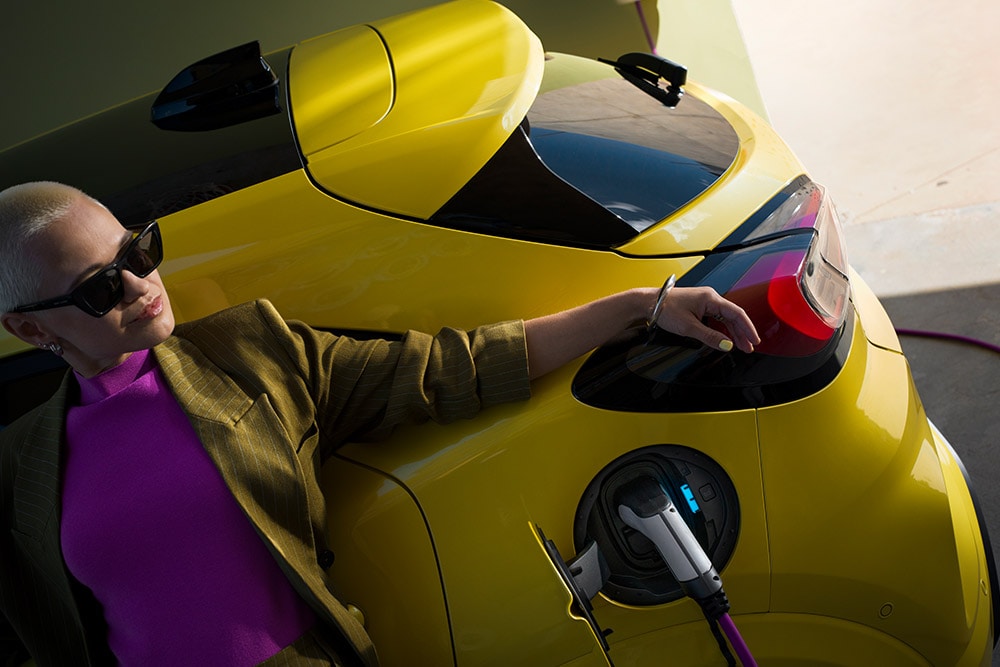 Primer plano de la parte trasera de un Ford Puma Gen-E® eléctrico enchufado a un cargador doméstico Wallbox.