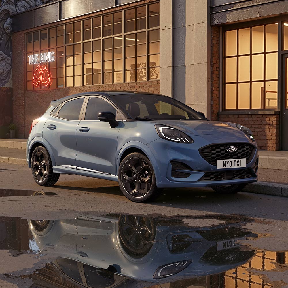 Um Ford Puma edição limitada Vapour Blue estacionado numa estrada urbana pouco iluminada à noite.