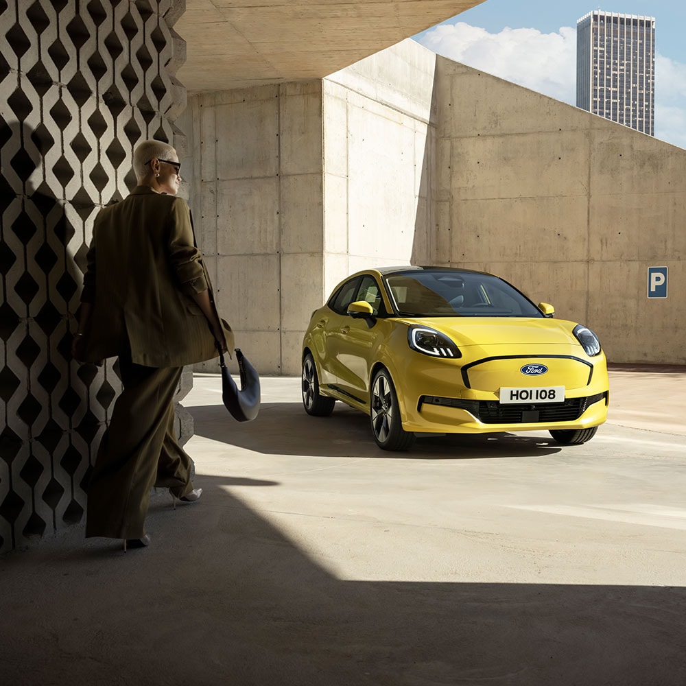 Uma pessoa caminha em direção ao novo Ford Puma Gen-E® elétrico em amarelo.