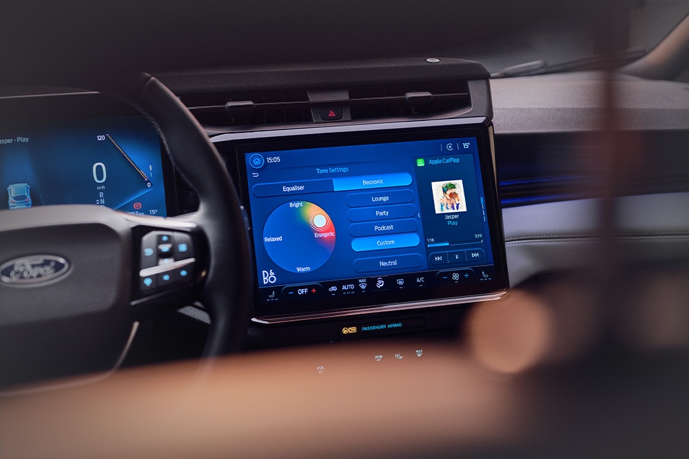 Grande plano do sistema de infoentretenimento com grande ecrã tátil mostrando B&O Beosonic no Ford Puma Gen-E Sound Edition.