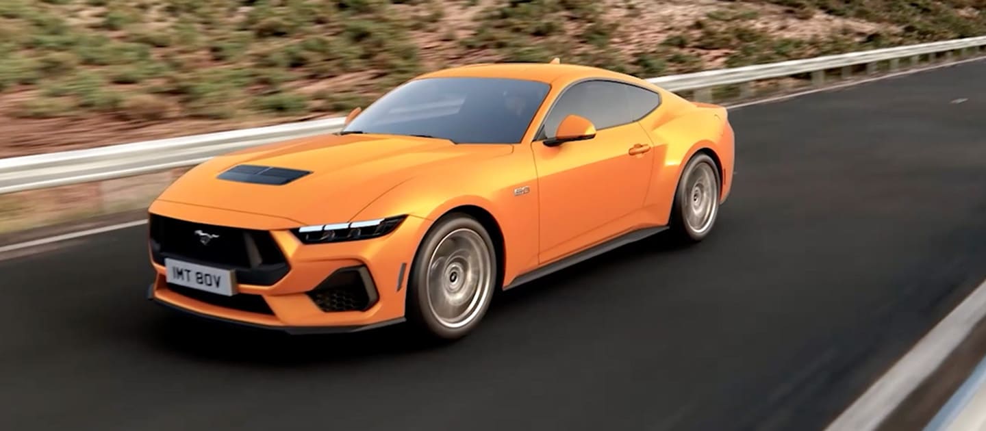Ford Mustang GT Fastback em Orange Fury a percorrer uma estrada de montanha