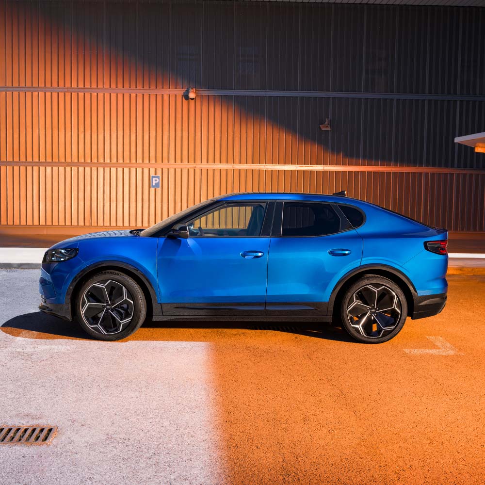 Vista lateral de um Ford Capri azul. A classificação de segurança de 5 estrelas do Euro NCAP de 2024 é exibida no canto superior direito. 