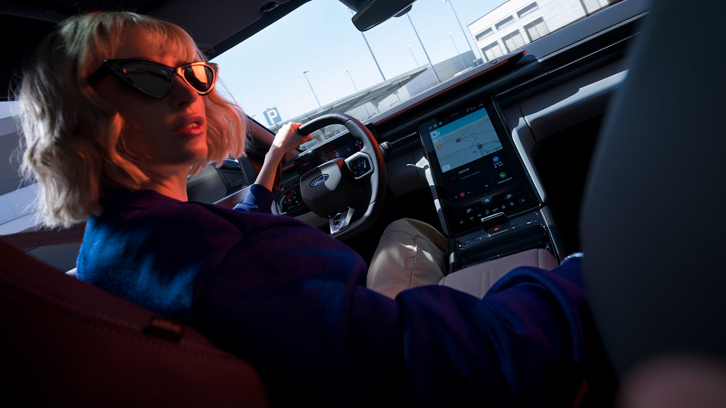 O novo Ford Capri® com vista para o volante, o painel de instrumentos e o grande ecrã tátil SYNC® Move.