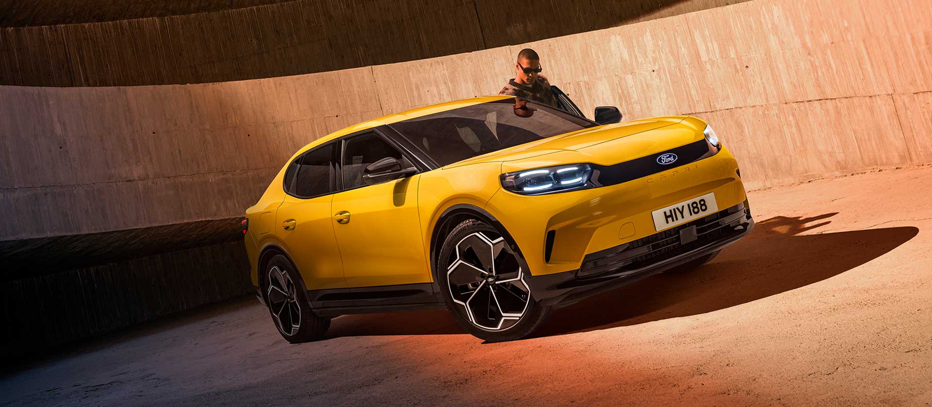 Um novo SUV elétrico Ford Capri® amarelo estacionado num parque de estacionamento.