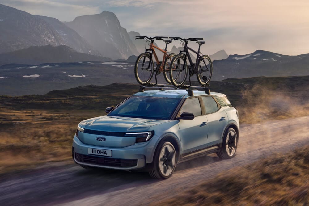Ford Explorer azul numa estrada rural, com duas bicicletas no suporte de bicicletas montado nas barras de tejadilho.
