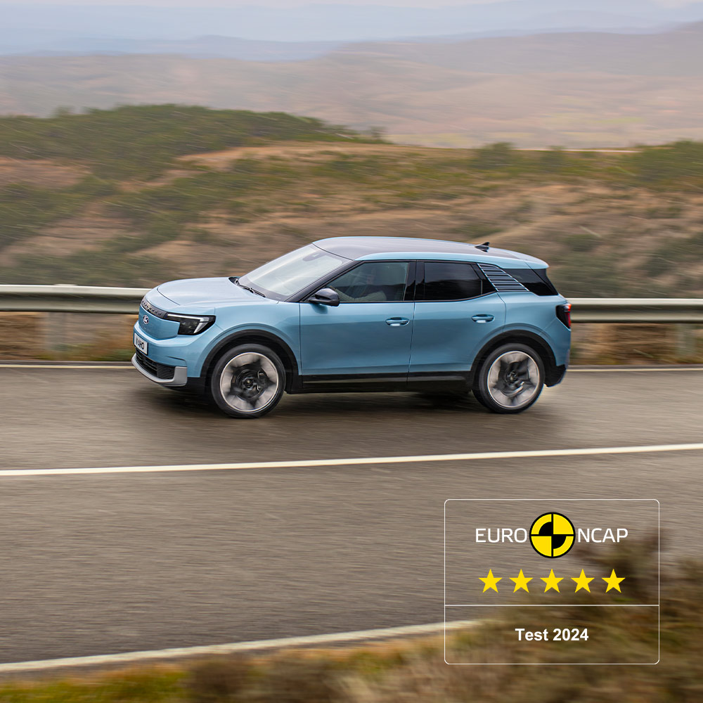 Um Ford Explorer azul a conduzir numa estrada de montanha, com o logótipo Euro NCAP 2024 de cinco estrelas no canto superior esquerdo. 
