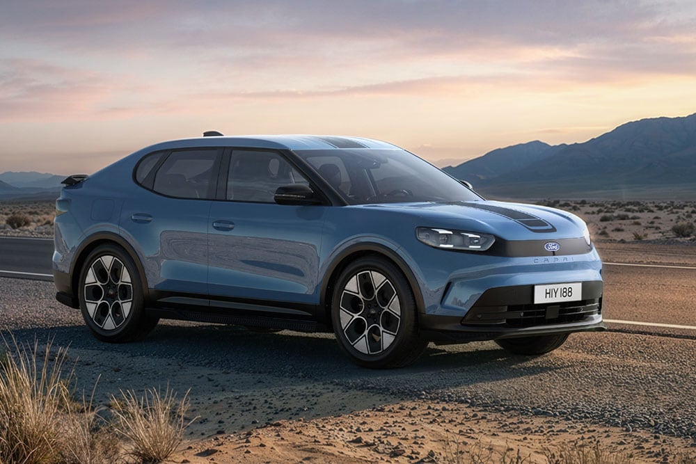 Ford Capri® Collection em azul a percorrer uma estrada de montanha poeirenta.