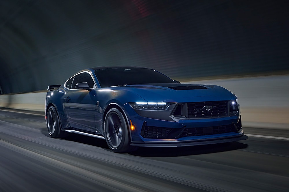 Um carro desportivo Ford Mustang azul vapor a atravessar um túnel.