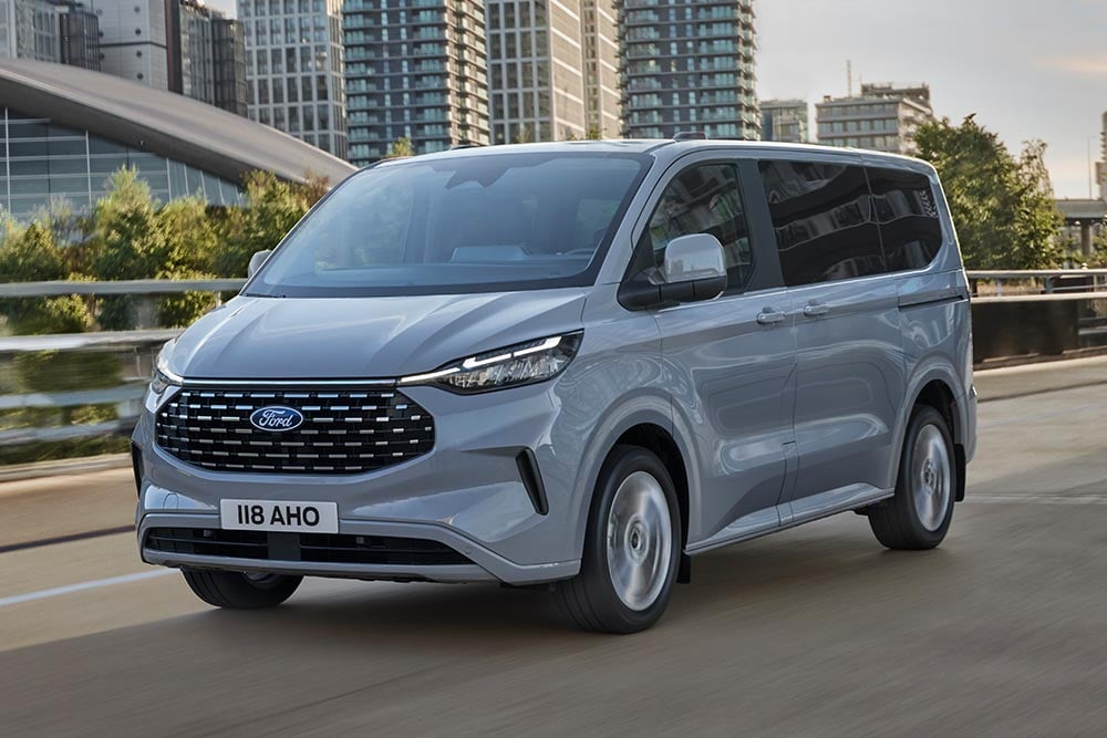 Um Ford Tourneo Custom prateado circula por uma rua da cidade.