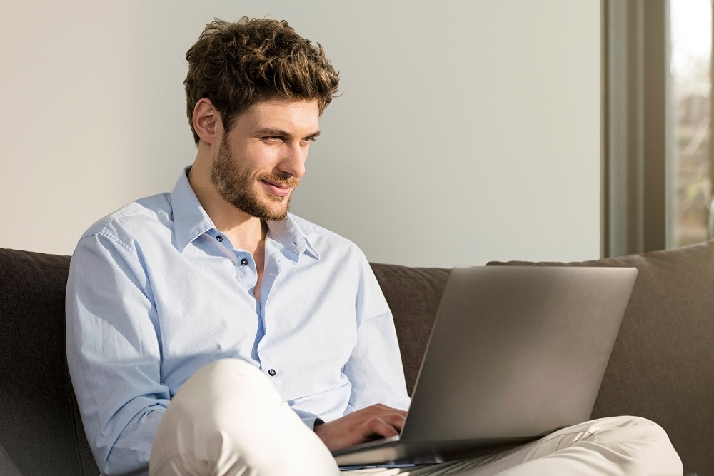 Homem ao computador portátil a utilizar a função de marcação de manutenção online da Ford