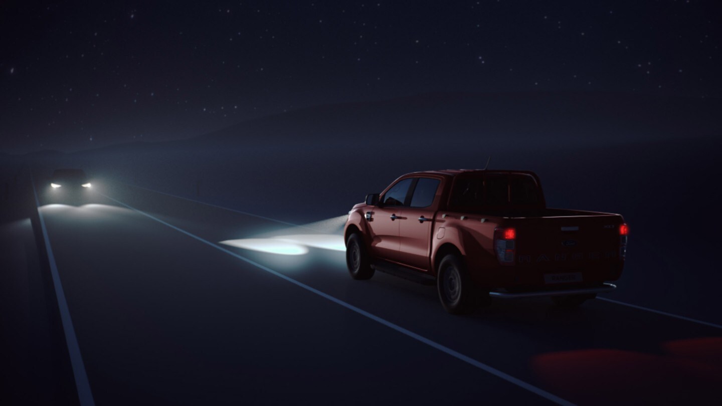 Red Ford Ranger driving in night with beams on