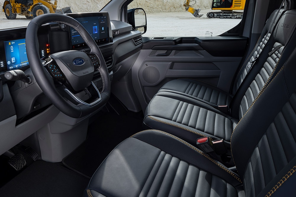 Interior de uma Ford E-Transit Custom Sport com bancos pretos e dourados.