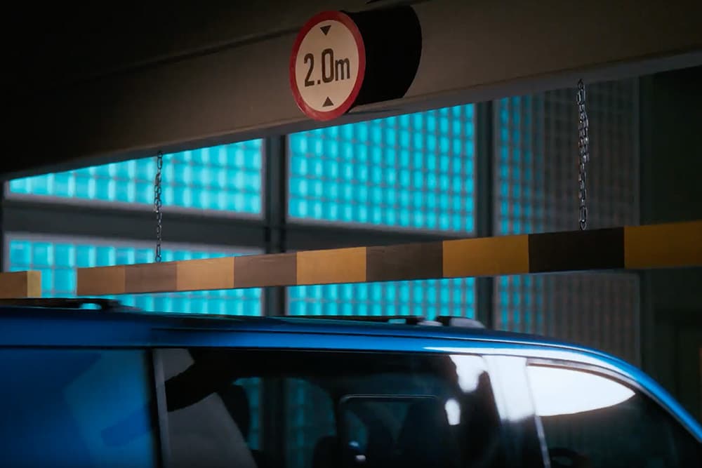 Ford E-Transit Custom azul a entrar numa garagem de estacionamento.