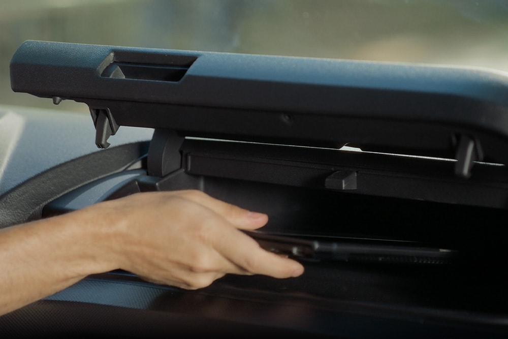 Mão a abrir um compartimento de arrumação na Ford E-Transit Custom.