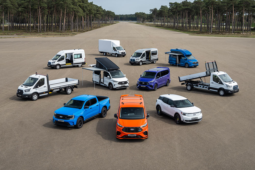 Coleção de furgões e carrinhas Ford Transit estacionados num aeródromo.