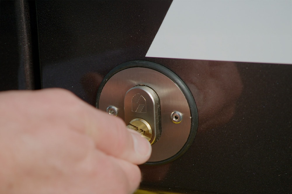 Mão a trancar a porta de um furgão com uma chave.