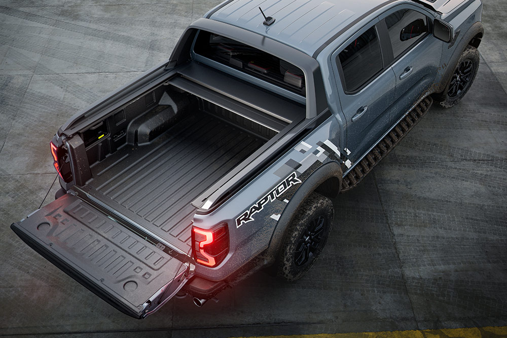 Vista traseira de um Ford Ranger Raptor, destacando a plataforma de carga e a porta da bagageira do veículo.