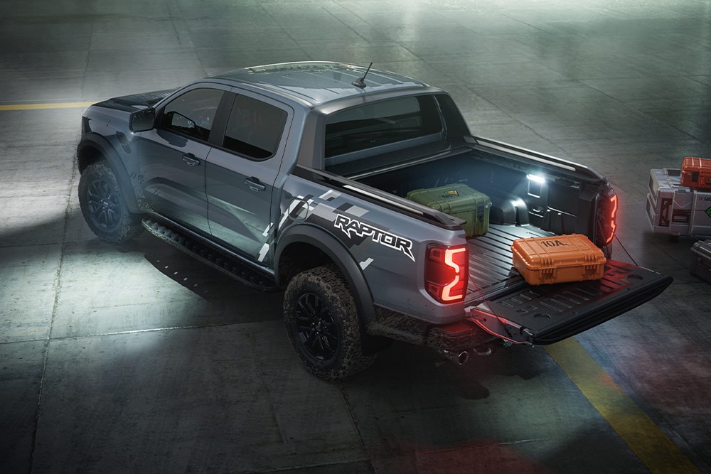 Vista traseira de um Ford Ranger Raptor, mostrando a iluminação exterior do veículo.
