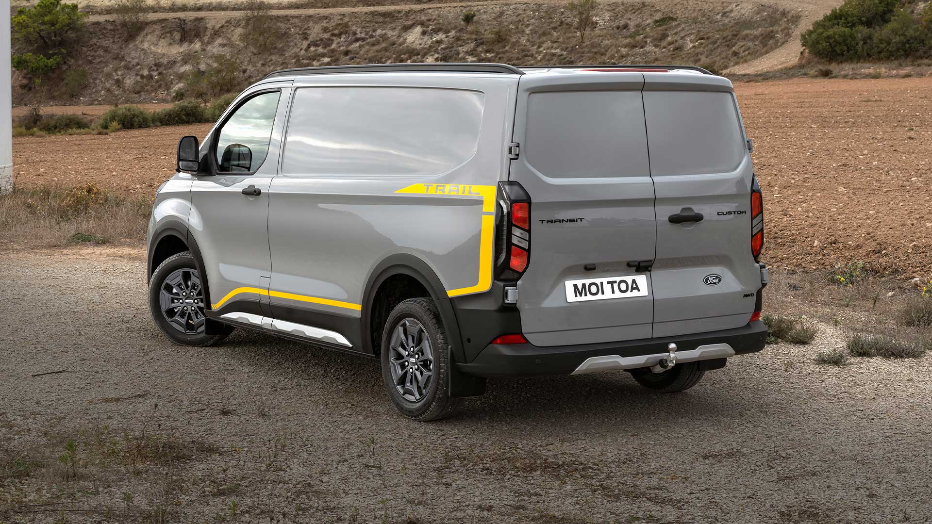 Vista da parte traseira de um furgão Ford Transit Custom Trail cinzento.