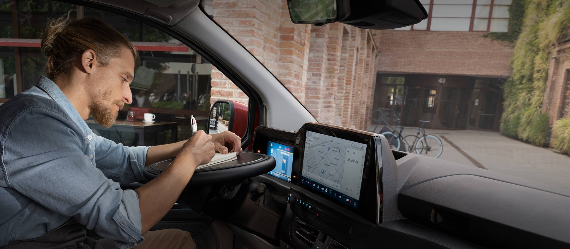 Pessoa a escrever num bloco de notas no interior de um Ford Transit Custom.