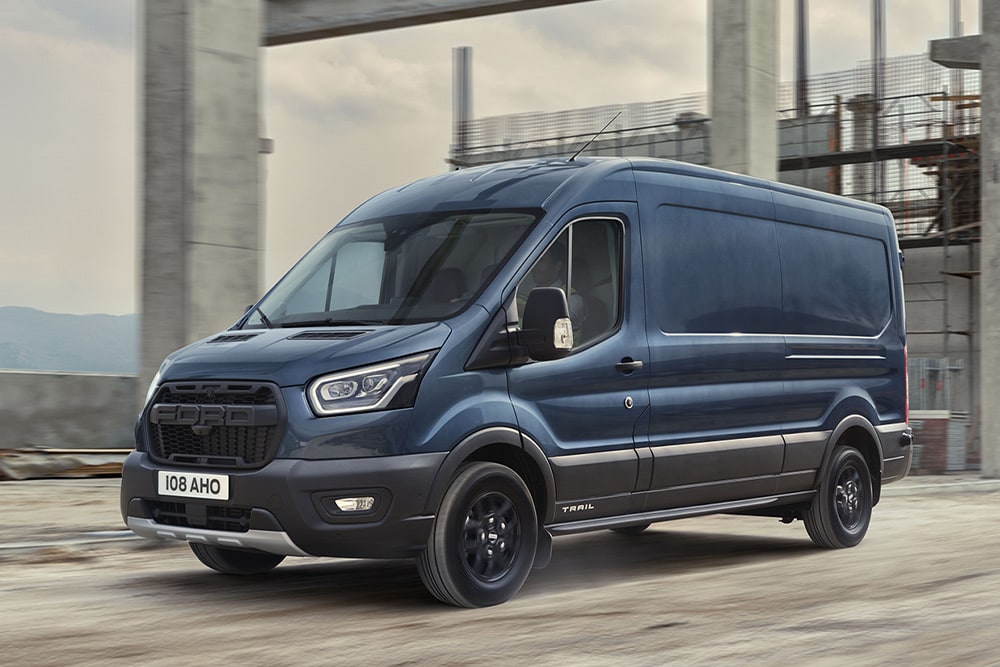 Carrinha Ford Transit com pacote Trail opcional a circular num parque industrial. 