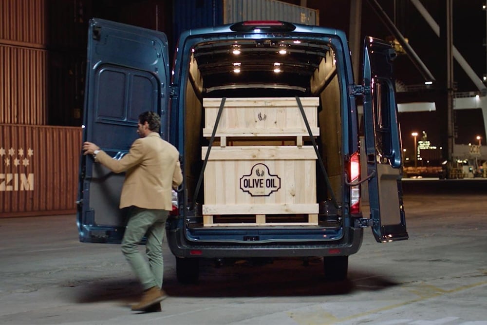 Carrinha Ford Transit com portas traseiras abertas, carga no interior.