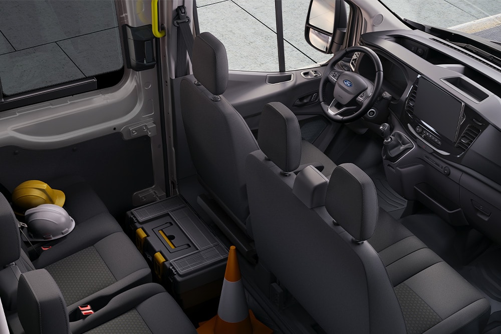 Interior da Ford Transit de cabina dupla com duas filas de bancos.