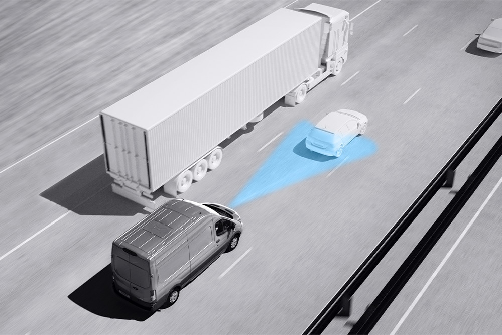 Desenho em tons de cinzento de uma carrinha Ford Transit com linhas azuis na estrada a indicar a utilização dos Sistemas Avançados de Assistência ao Condutor.