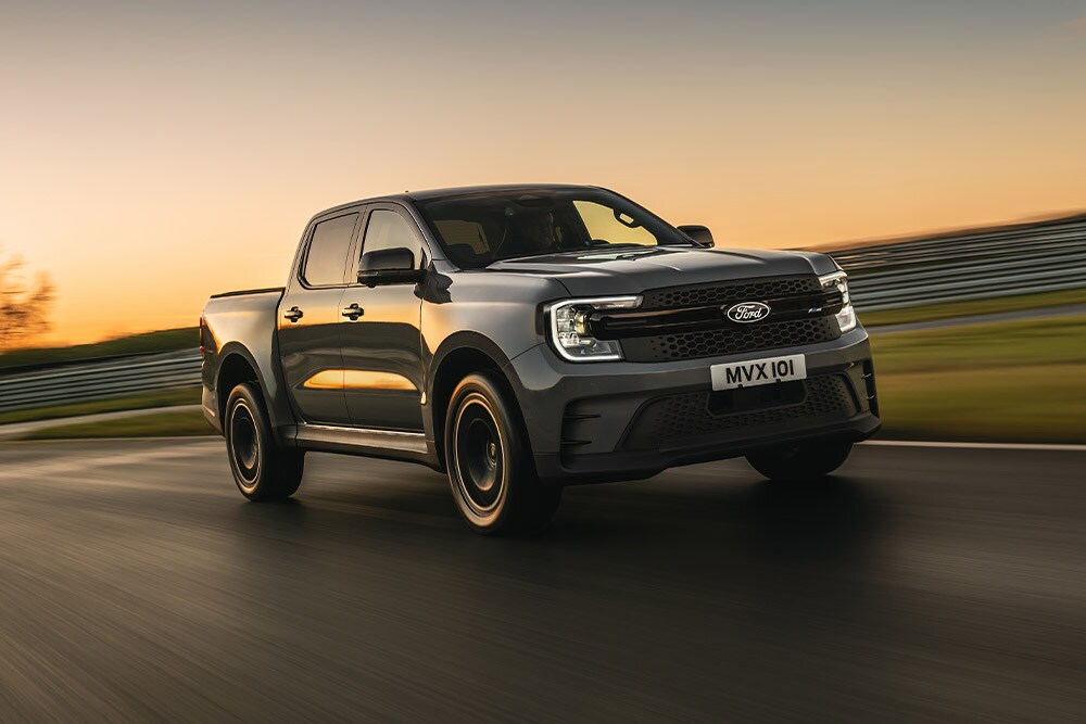 Uma Ford Ranger Platinum cinzento-escura a circular numa pista ao pôr do sol.