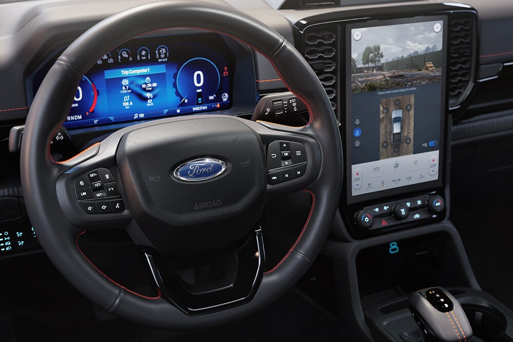 Vista interior da Ford Ranger Wildtrak a mostrar o volante e a consola central SYNC™ 4 com ecrã tátil de 12 polegadas.
