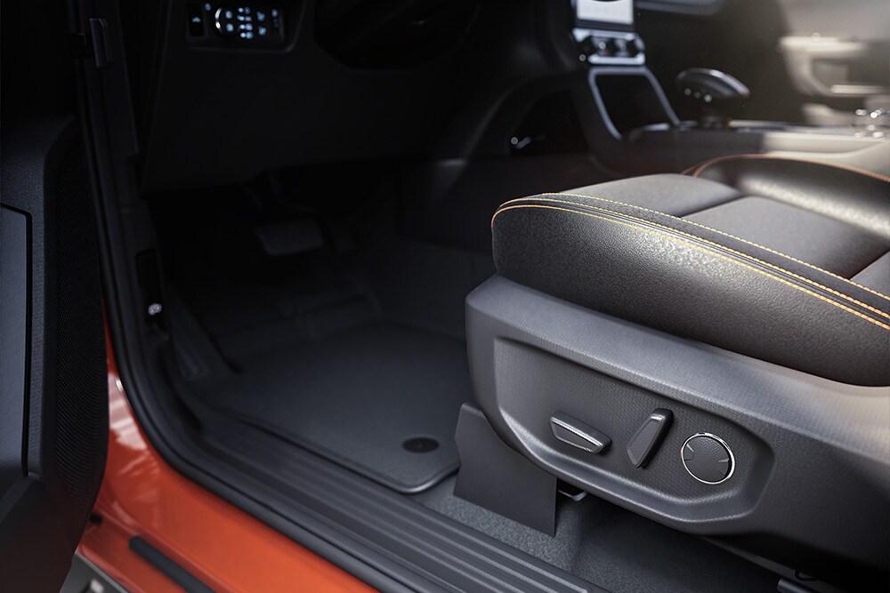Grande plano do interior de uma Ford Ranger, com foco nos bancos da frente.
