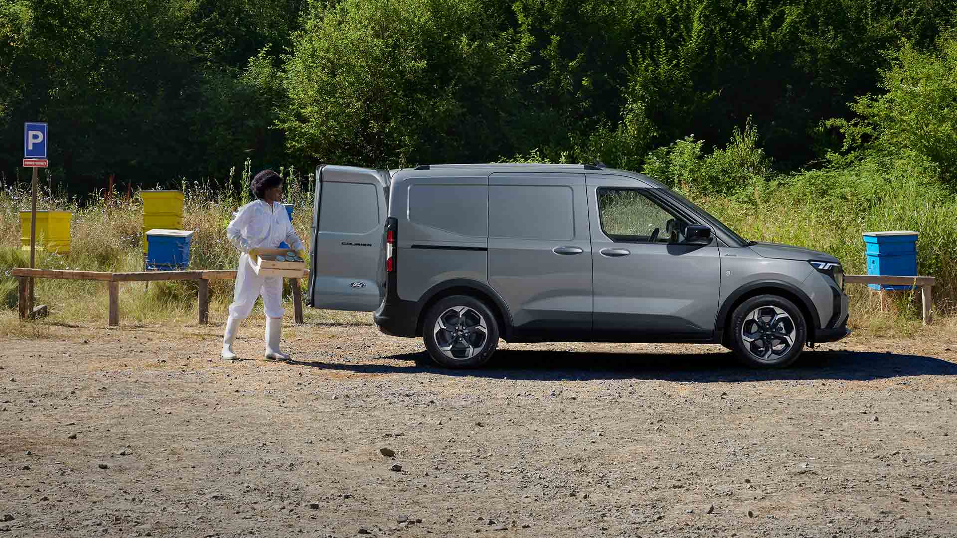 Apicultor retirando mercadoria da Transit Courier na cor cinza